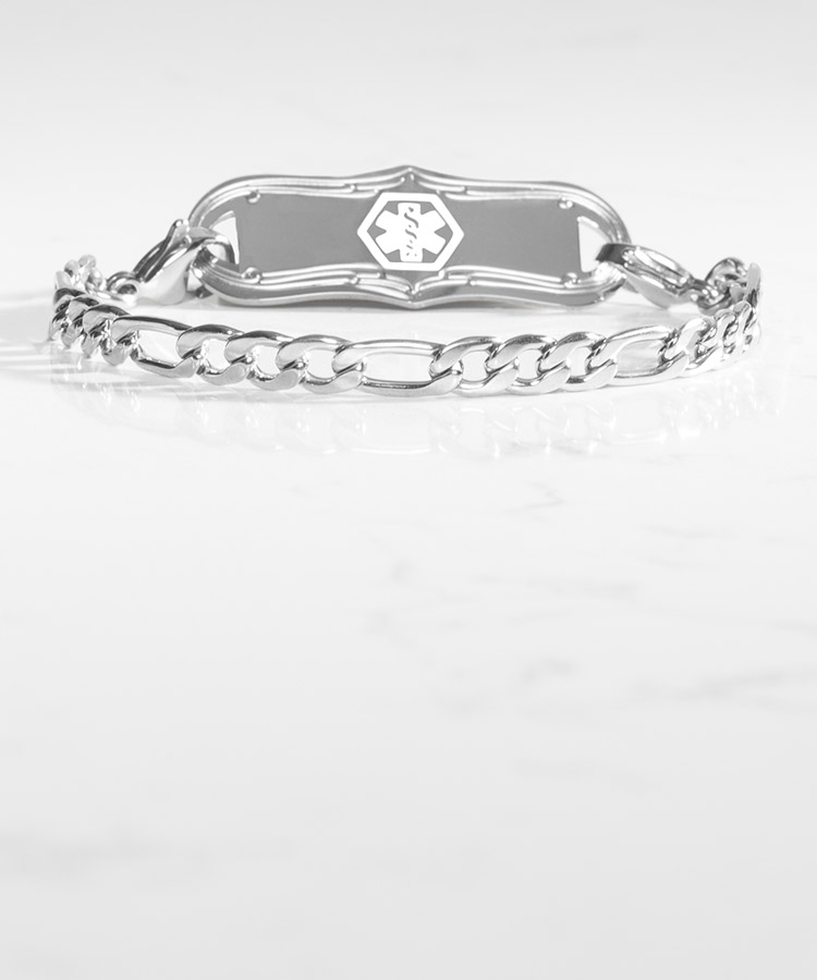 Woman with hand on book wearing silver tennis bracelet with mother of pearl medical ID tag