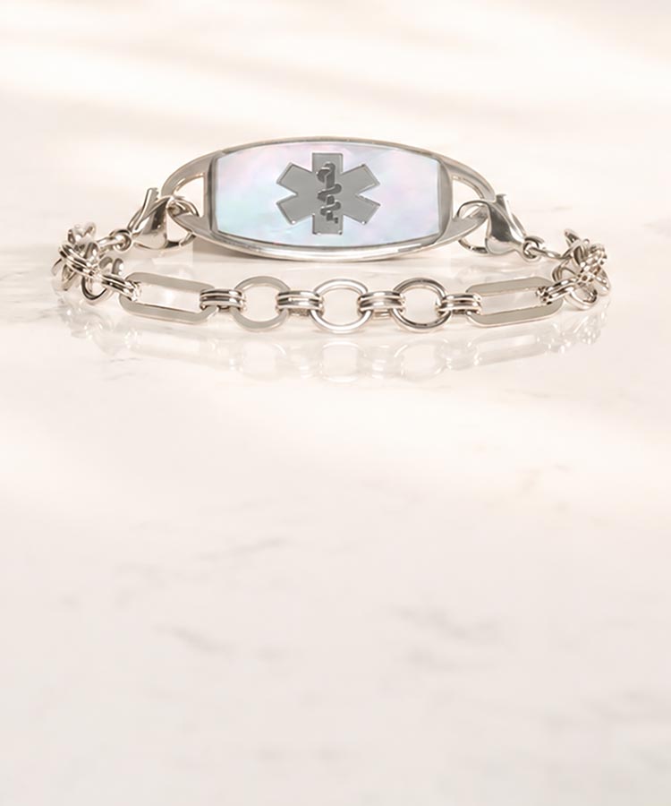 Stainless steel medical ID chain with mother of pearl medical alert tag on marble background
