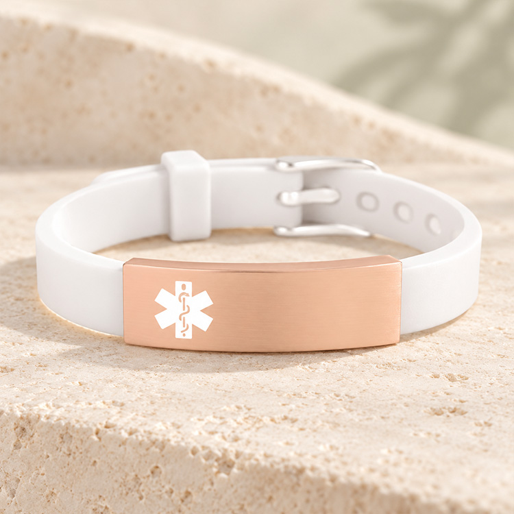 White silicone with rose gold medical ID tag or gold medical ID tag on marble background