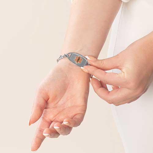 Woman showing silver and rose gold two-tone medical ID tag