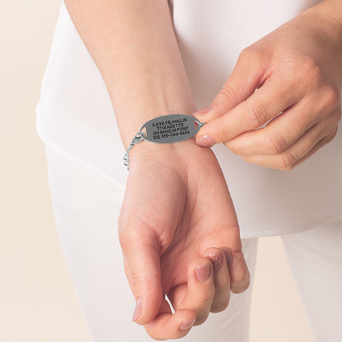 Woman showing custom laser engraved medical ID tag