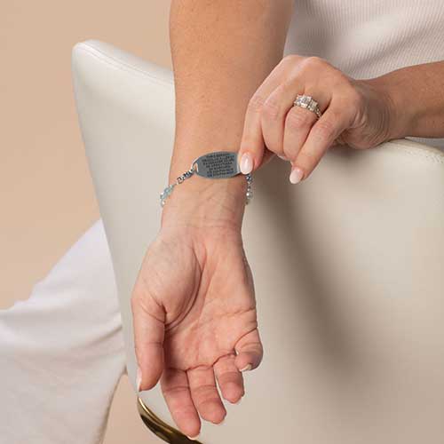 Woman wearing custom laser engraved medical ID tag in silver
