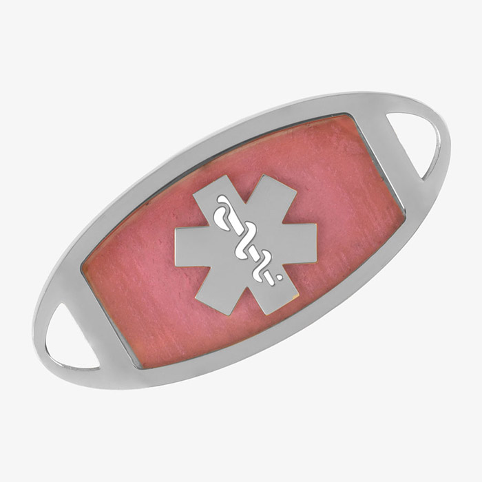 Close-up of a pink medical ID tag with a silver medical symbol in the center and an oval-shaped silver border with connector openings on each end.