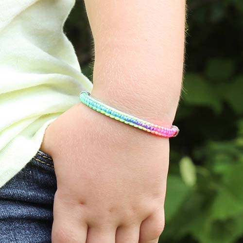 Girl wearing the Sunny Skies Medical ID Bracelet with the front of the single bank multi-color cord showing several colors