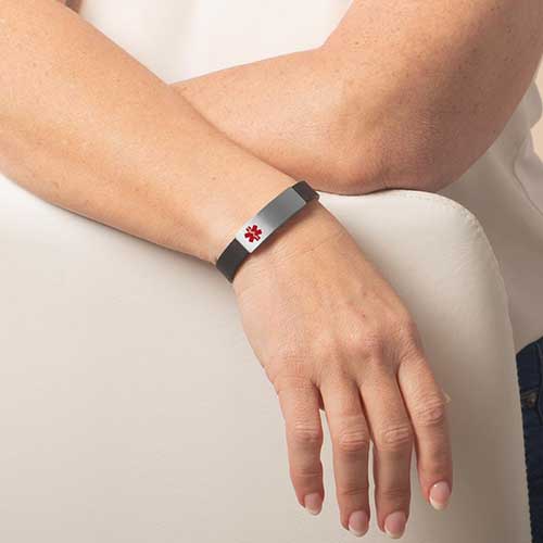 Woman wearing black silicone medical ID bracelet with silver medical alert tag