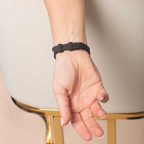 Woman displaying the watch style clasp on her black silicone medical ID bracelet.