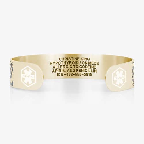 Back of a gold-tone medical ID cuff showing custom medical engraving and white medical symbols on both ends.