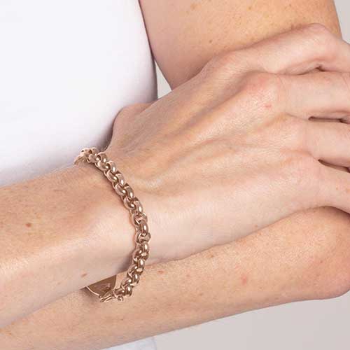 Woman wearing rose gold tone stainless steel rolo chain medical alert bracelet.