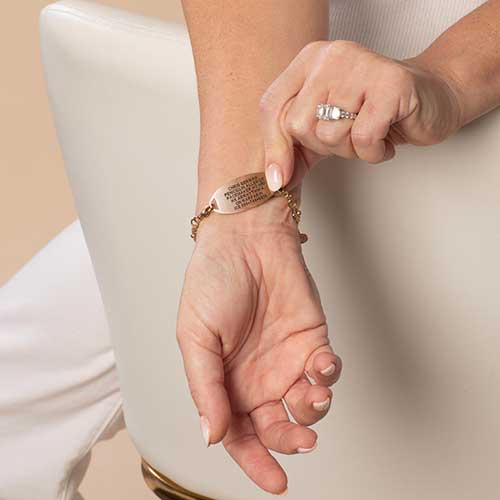 Woman showing custom laser engraved rose gold medical alert tag