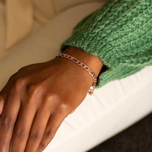 Woman wearing rose gold stainless steel medical ID bracelet in figaro style chain