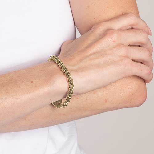 Woman wearing gold tone stainless steel rolo chain medical ID bracelet.