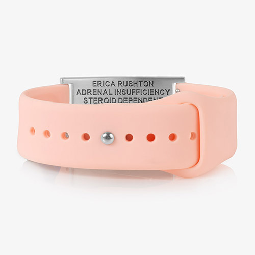 Rear view of the same pink silicone medical ID bracelet, showing the adjustable strap with holes and a stainless steel plate engraved with medical information.