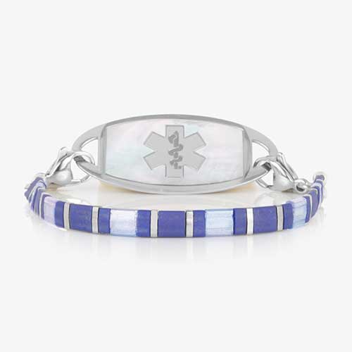 Silver-tone medical ID bracelet featuring a mother-of-pearl ID tag with Star of Life symbol and blue tile-style beaded bracelet chain.