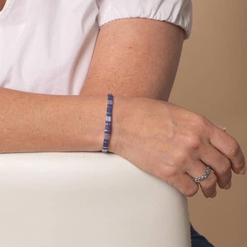 Woman wearing a blue and silver tile-style medical ID bracelet chain, showcasing a sleek, modern design with comfortable everyday wear.