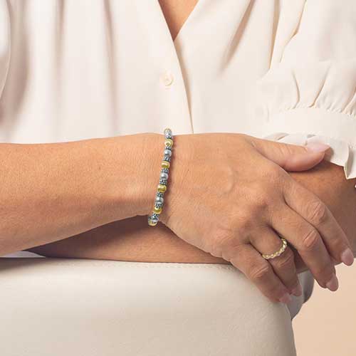 Woman wearing gold and silver beaded bracelet