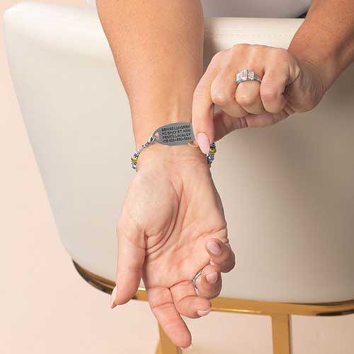 Woman displaying custom laser engraving on her medical ID Tag