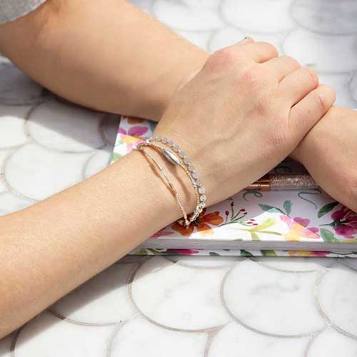 Woman wearing rose gold and silver medical alert bracelet with beads