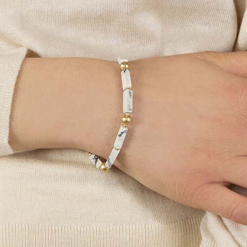Woman wearing gold and howlite beaded stretch medical alert bracelet