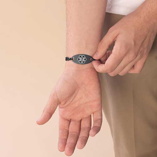 Man displaying black and charcoal medical ID tag.