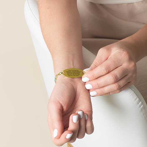 Woman showing custom engraved medical ID tag.