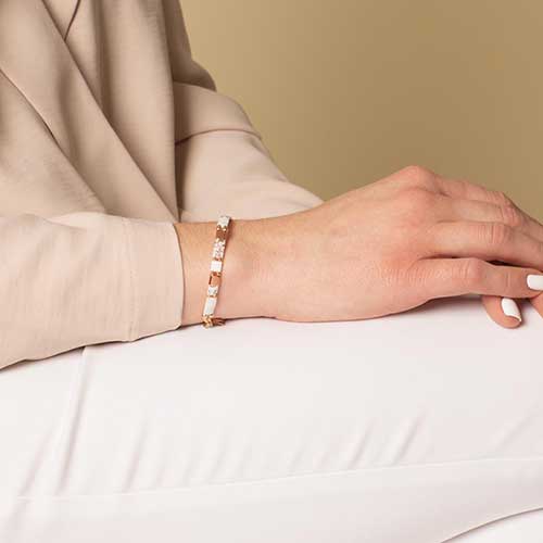 Woman wearing white and rose gold accent stretch medical ID bracelet