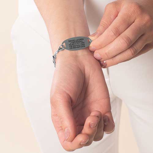 Woman wearing stainless steel medical ID tag with premium laser engraving.