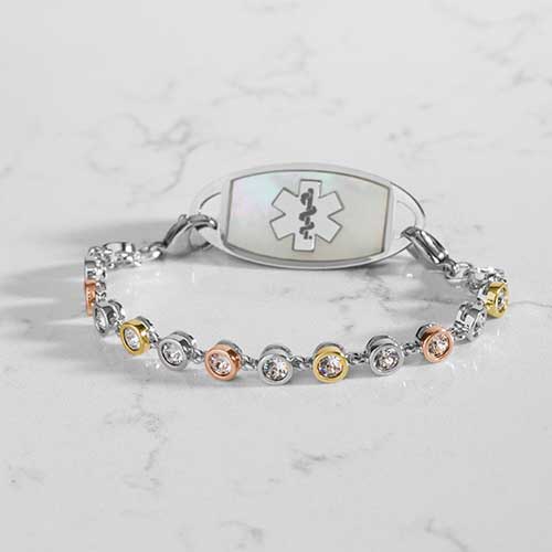 Bracelet featuring individually set, round cubic zirconia crystals, in alternating silver, rose and gold tones. Attached to a silver and gold medical ID tag.
