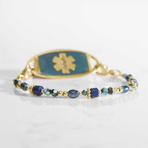 Blue and gold beaded medical ID bracelet on jewelry elastic with gold tone lobster clasps and sapphire blue decorative med ID tag.