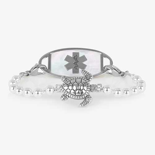Silver beaded bracelet featuring a sea turtle centerpiece, attached to a stainless steel medical ID with mother of pearl inlay.