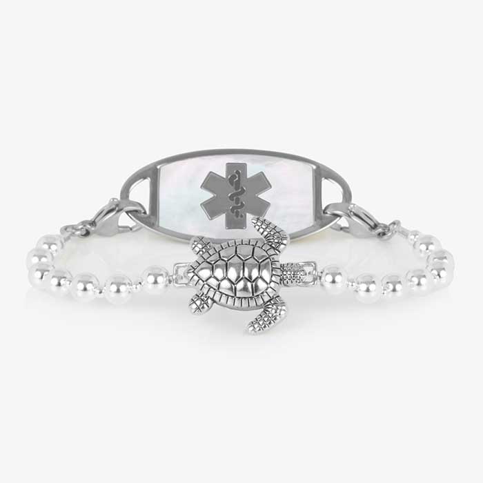 Silver beaded bracelet featuring a sea turtle centerpiece, attached to a stainless steel medical ID with mother of pearl inlay.