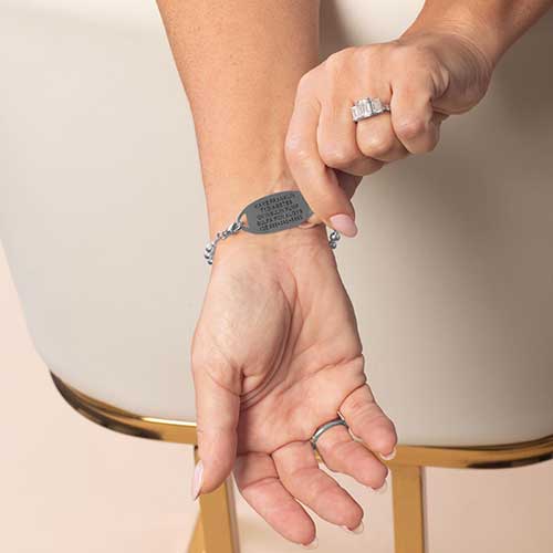 Model displaying the custom laser engraving on the back of her medical ID Tag