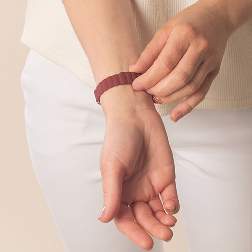 Urban MagSport medical ID bracelet in Merlot on wrist, featuring a magnetic adjustable silicone band and stainless steel ID tag with gold-tone medical symbol