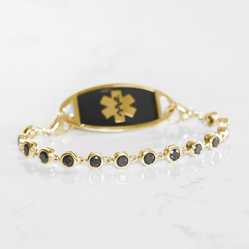 Gold medical ID bracelet with black crystal chain and black inlay plaque, featuring a Star of Life symbol for elegant safety wear.