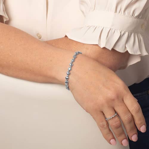 Woman wearing Silver heart beaded stretch medical alert bracelet with elegant minimalist jewelry styling and feminine everyday fashion look