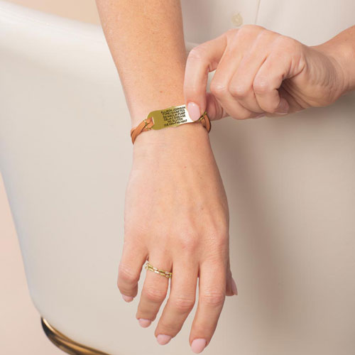 Woman wearing the Avery SmartSize Medical ID Bracelet with a suede copper tone leather band with the engraving flipped over