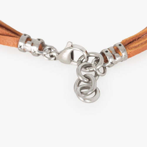 Brown suede leather bands attached to a silver clasp, fastening with a lobster claw clasp