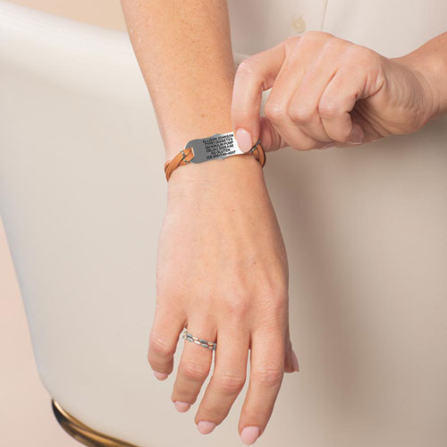 Woman wearing the Avery SmartSize Medical ID Bracelet with a suede copper tone leather band with the engraving flipped over