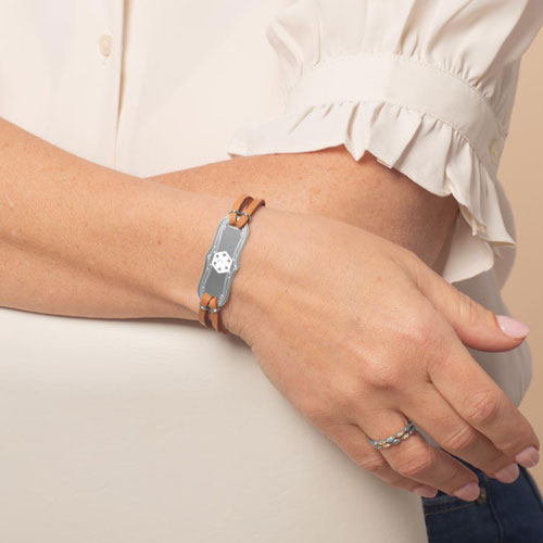 Woman wearing Avery SmartSize Medical ID Bracelet with suede copper tone leather band and adjustable chain with a Silver Medical ID with the white medical symbol