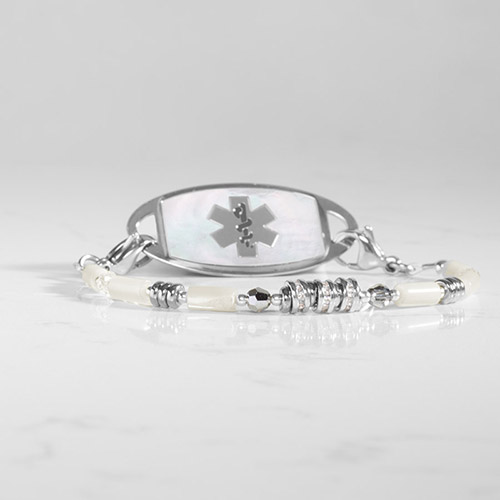 Fashionable women’s medical alert bracelet with silver-tone hardware, crystal accents, and luminous Mother of pearl white beads