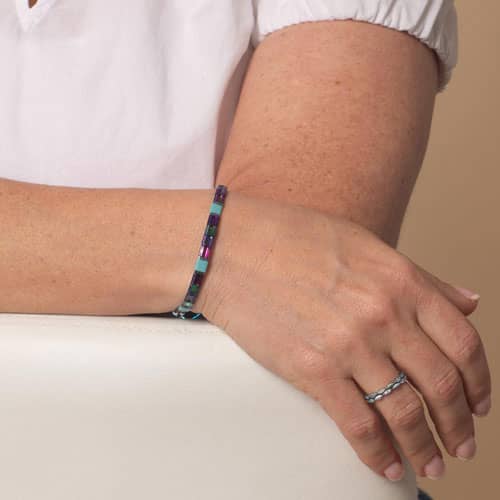 Woman wearing the Twilight bracelet, a vibrant interchangeable style designed to pair with compatible medical ID tags.