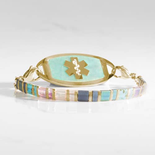 Gold-tone medical ID bracelet with rectangular beads in aqua, blue, pink, clear, and iridescent tones and a medical symbol tag.