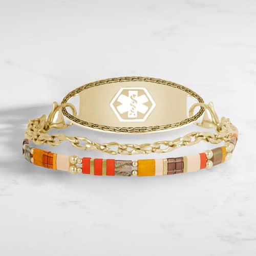 Three-strand gold-tone medical ID bracelet with colorful rectangular beads and a white medical symbol on the ID tag.