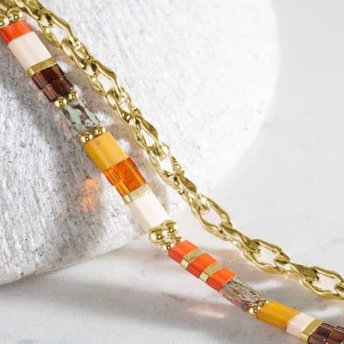 Close-up of the bracelet highlighting colorful rectangular beads in orange, cream, brown, green, and red with gold-tone accents.