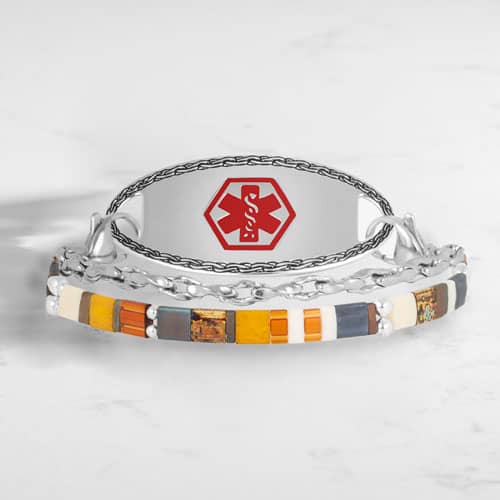Two-strand silver-tone medical ID bracelet with colorful rectangular beads and a red medical symbol, shown on a white surface.