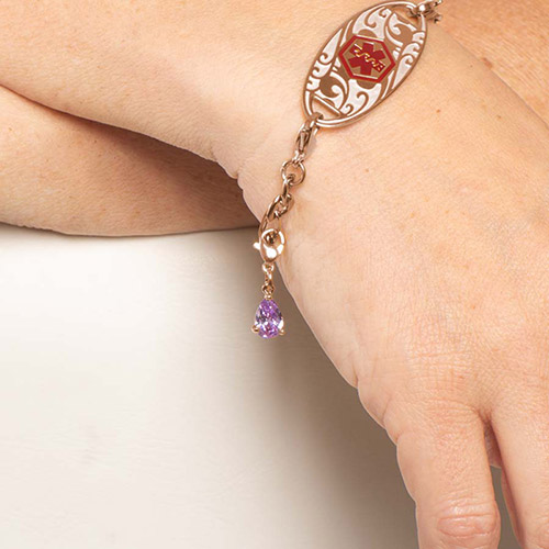 Teardrop-shaped amethyst Lynn charm in rose-tone prong setting, shown on Lauren’s Hope medical ID bracelet for women
