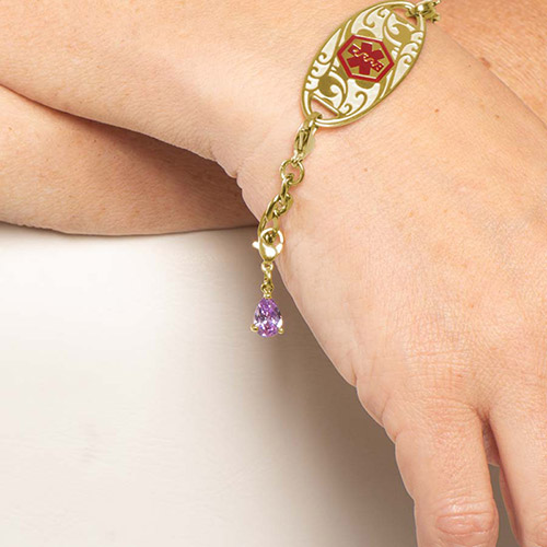 Elegant Lynn Amethyst Teardrop Charm in gold-tone prong setting, shown on a Lauren’s Hope medical ID bracelet for women