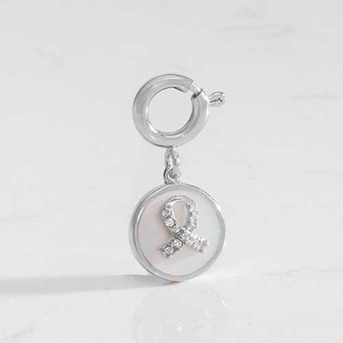 Silver tone round charm with mother of pearl inlay and silver awareness ribbon with inset crystals