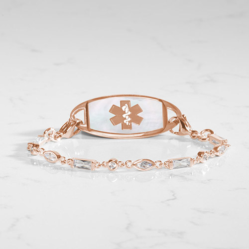 Rose gold tone medical ID bracelet with round, rectangle, and oval clear cubic zirconia crystals paired with rose gold tone med ID tag with mother of pearl inlay and rose gold medical symbol.