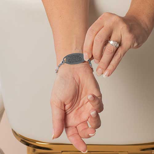 Woman showing custom laser engraved medical ID tag