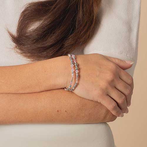 Woman wearing lavender and pink beaded medical ID bracelet with pearl accents